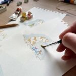 An artist painting a watercolour cat for a birthday card