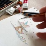 An artist painting an illustration for a greetings card for a birthday