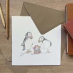 A greeting card with two puffins