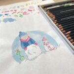 An artist illustrating a Christmas greetings card