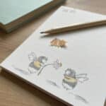 A lined notepad with bee design