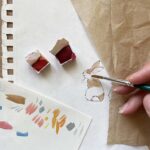 An artist painting a watercolour rabbit