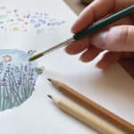 An artist illustrating a card with watercolour lavender