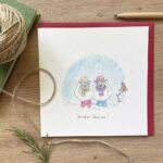 A Christmas card with two sheep in the snow