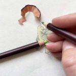 An artist drawing a tortoise design for a greeting card